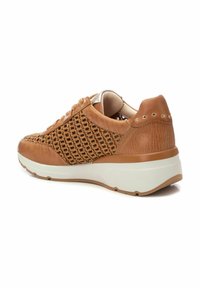 Zapatilla de cuero marrón con paneles de malla tejida, cuello acolchado y suela blanca. Presenta studs decorativos dorados en el talón.