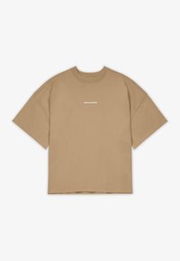 T-shirt oversize beige a maniche corte con collo rotondo e piccolo testo bianco "PEGADOR" centrato sul petto su sfondo bianco.