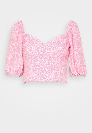 Roze cropped blouse met wit bloemenpatroon en pofmouwen tot aan de ellebogen, met een sweetheart-halslijn.