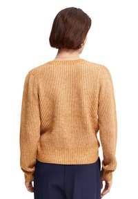 Pull en maille côtelée texturée de couleur orange-brun chaud avec manches longues et encolure arrondie ; taille et poignets ajustés.