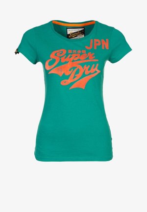 T-shirt vert ajusté à manches courtes avec un texte orange vif "Super Dry" et "JPN" sur le devant et un petit logo sur la manche gauche.