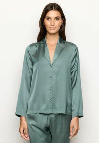Satijnen pyjama-top in gedempt groen, met een notched kraag, lange mouwen en knopen aan de voorkant. Soepele textuur, reguliere pasvorm en eenvoudig ontwerp.