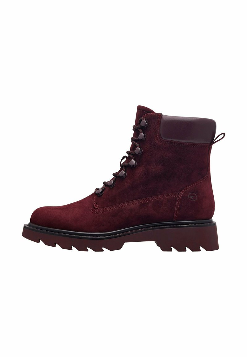 Botine din suede burgund cu o talpă groasă și robustă, ochiuri metalice și un guler căptușit. Are un tab cu care se poate trage pentru a facilita încălțarea.