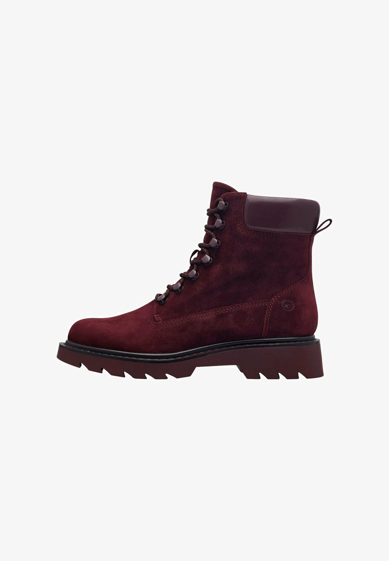 Stivaletto in suede bordeaux con suola spessa e robusta, occhielli metallici e colletto imbottito. Dotato di un pratico passante per indossarlo facilmente.