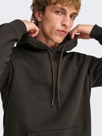 Sweat à capuche vert foncé avec une poche kangourou, des cordons de serrage et des poignets côtelés. Tissu doux et coupe décontractée, avec un design simple.