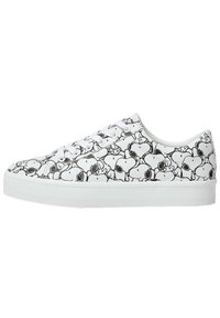 Baskets basses blanches avec des visages du personnage Snoopy en noir et blanc imprimés partout, lacets blancs et semelle blanche.