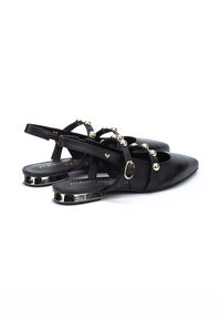 Zapatos slingback de cuero negro con puntas afiladas, que presentan acentos esféricos dorados y un detalle metálico en el tacón. Diseño minimalista con correas en el tobillo.