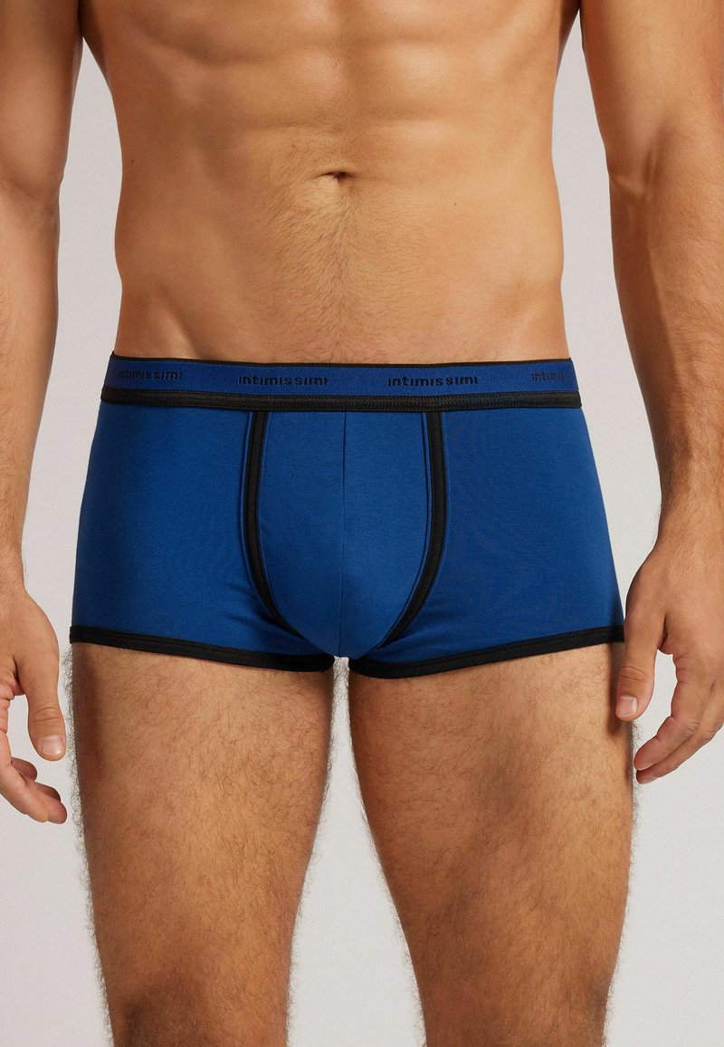 Modré pánské boxerky s černým páskem a lemováním. Měkká látka, přiléhavý design, s hladkým povrchem a bez viditelných vzorů.