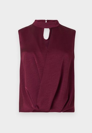 Blouse sans manches rouge foncé avec col montant et découpe en forme de goutte à l'avant, présentant des détails de tissu drapé léger.