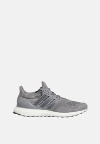 Šedá sportovní bota s texturovaným pleteným svrškem, třemi kontrastními pruhy a bílou polstrovanou podrážkou, označená jako "ultra boost".