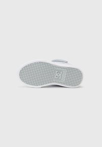 Weiße Sneaker-Sohle mit texturiertem Gummigriffmuster; enthält ein eingearbeitetes Logo. Der Mittelsohlenbereich ist glatt und weiß, mit einem himmelblauen Designelement im oberen Bereich.