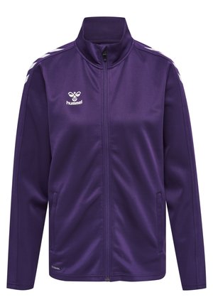 Veste de survêtement violette avec un col haut, fermeture éclair à l'avant et logo blanc. Comprend des bandes en chevron blanches sur les épaules et des poches latérales. Texture lisse.