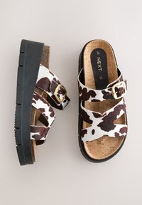 Lehmamustriga sandaalid mustade platvormpõhjadega, millel on korksisetallad ja kaks reguleeritavat rihma kuldsete pandlatega kindlaks istuvuseks.
