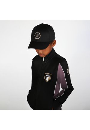Giacca nera con zip e pannelli accentati in viola, dotata di una targhetta con logo dorato e di un cappellino nero abbinato con logo esagonale.