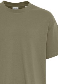 Maglietta in cotone verde oliva con scollo rotondo, maniche corte e vestibilità comoda. Tessuto liscio con dettagli sottili di cucitura.