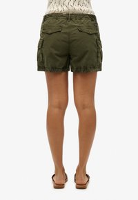 Shorts cargo verts olive avec plusieurs poches, taille élastique et ourlet effiloché. Fabriqués en tissu doux et léger.