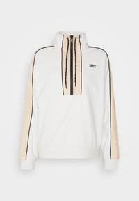 Vit sweatshirt med hög krage, halv dragkedja, beige sidpaneler och svarta detaljer. Har Levi's-logotyp på bröstet. Mjuk tygtextur.