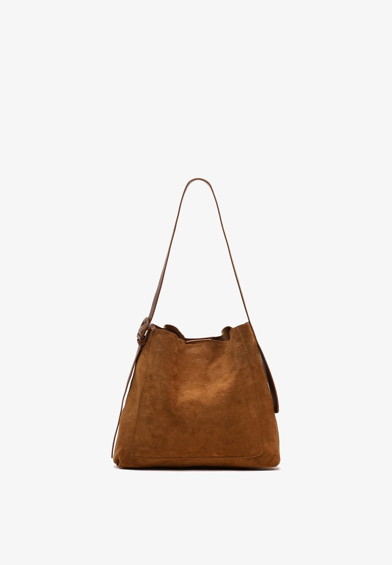 Borsa a secchiello in suede marrone con una texture morbida, apertura superiore e una lunga tracolla. Presenta un design minimalista e linee pulite.