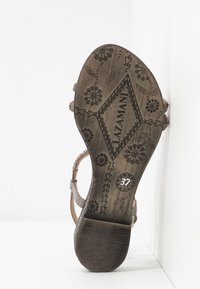 Gray sandal with leather straps, textured insole, decorative floral embossing, and size 37 marking on the sole.