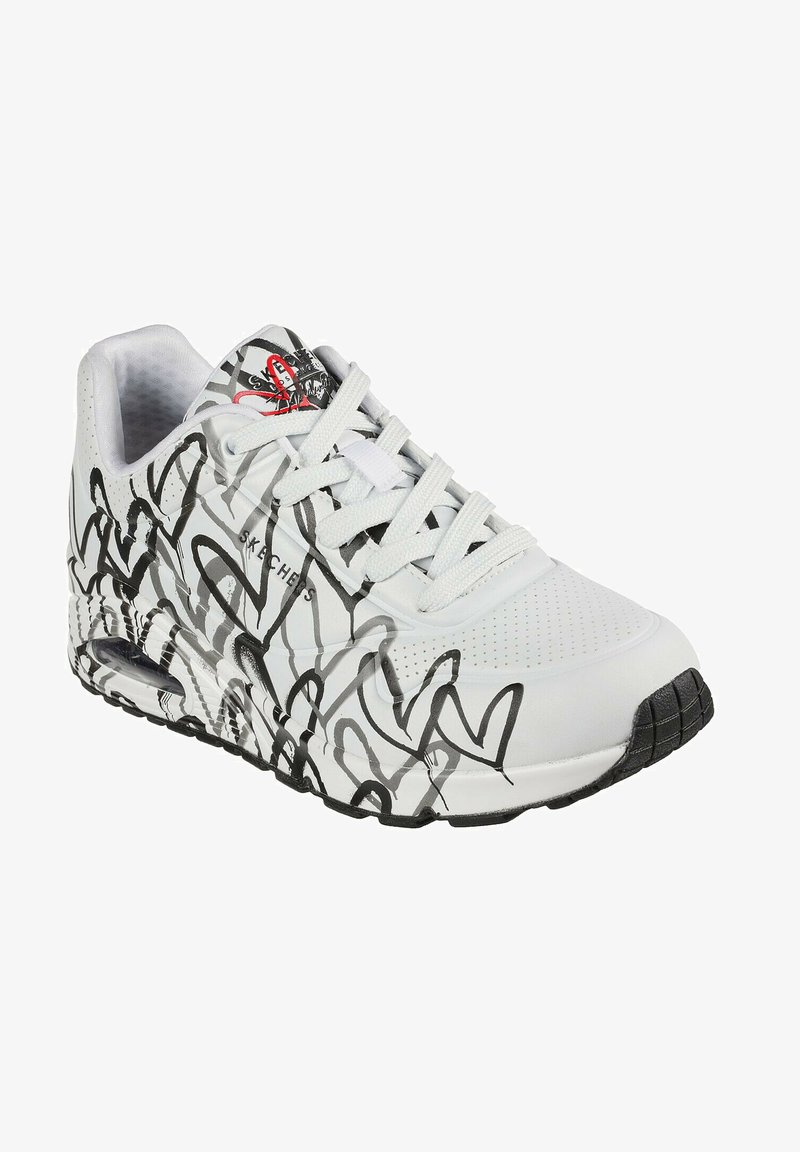 Witte sneaker met zwart abstract krabbelpatroon, geperforeerde details en vetersluiting. Voorzien van een gewatteerde kraag en een zwarte rubberen zool.