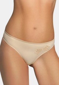 Beige onderbroekjes van gladde stof hebben een decoratieve strik aan de zijkant en een zacht golvende rand langs de tailleband.