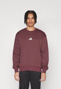 Bordeaurode sweatshirt van een katoenmix met lange mouwen, geribbelde mouwen en een ronde hals met een wit Adidas-logo op de borst.