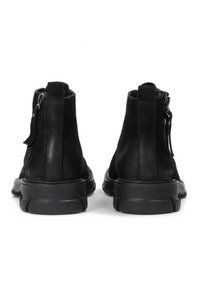 Botas de tobillo de cuero negro con una textura suave, cierre de cremallera y suelas acolchadas. Presentan suelas de goma duraderas y un diseño minimalista.