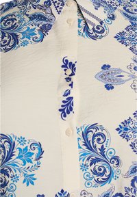 Weißes Hemd mit Knopfleiste, verziert mit blauen und marinefarbenen Blumen-Paisley-Mustern und klassischem Kragen.