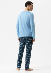 Blaues Langarmshirt mit rundem Ausschnitt, kombiniert mit marineblauen Pyjamahosen mit weißem Rautenmuster. Weicher Stoff, lockere Passform.