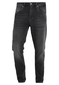 Czarne jeansy z denimu o prostym kroju. Posiadają przednią kieszeń z czerwonym przeszyciem, dwie tylne kieszenie oraz zapięcie na guzik w pasie.