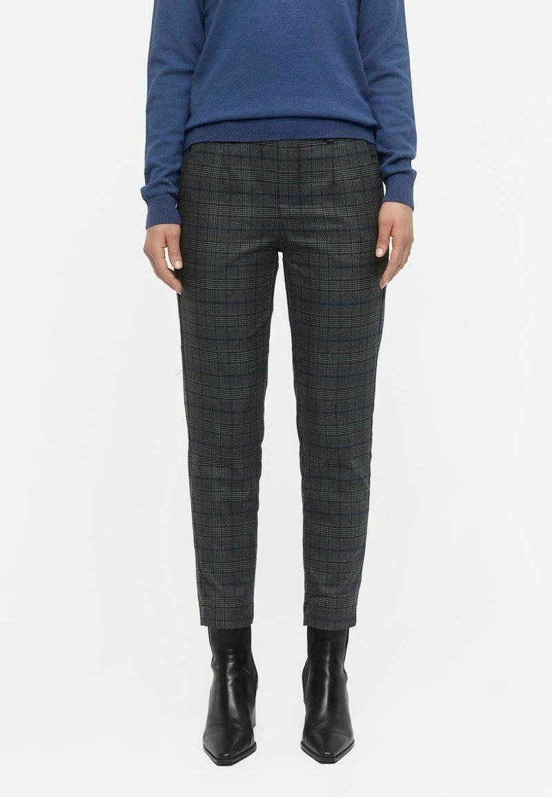 Plaid trousers in dark gray with a tailored fit, featuring a fine check pattern and slim legs. Paired with black, pointed-toe ankle boots.