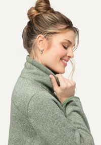 Grön, texturerad fleecejacka med hög krage och kontrasterande inre mudd. Har dragkedja och subtilt melerat mönster.