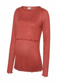 Gravid långärmad topp i rostfärg, ribbad textur, med en scalloped nederkant och en figursydd design som rymmer en växande mage.