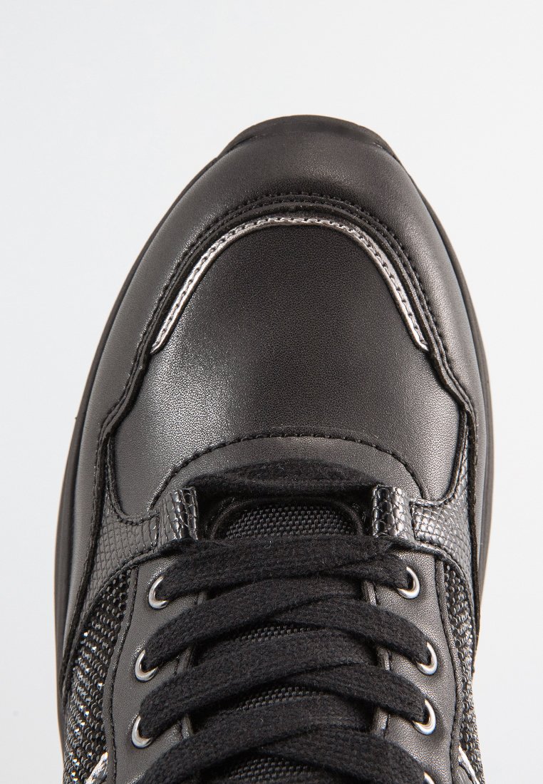 Zwarte sneaker met een glad leren bovenwerk, gestructureerde meshpanelen, metalen oogjes en zwarte veters. Rond neuzen met een versterkte naad.