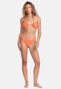 Oranžový bikini set s nařaseným bandeau topem a vysokým pasem, vyrobený z texturované látky s tenkými ramínky.