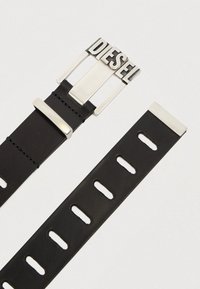 Μαύρη δερμάτινη ζώνη με μεγάλη ασημένια αγκράφα που φέρει τη λέξη "DIESEL", λεία υφή, με λουρί που διαθέτει πολλαπλές τρύπες για ρύθμιση.