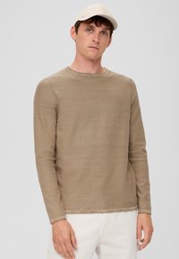 Beige shirt met lange mouwen van textuurstof, met een ronde hals en gestikte zoom. Gecombineerd met off-white broek.
