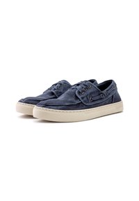 Scarpe da boat in canvas blu navy con finitura testurizzata, design con lacci e suola in gomma beige con un logo discreto sul lato.