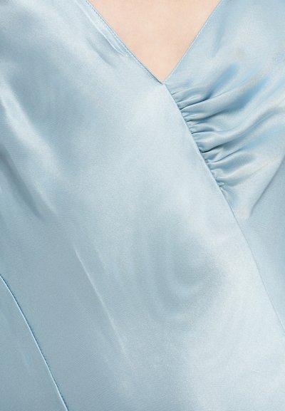 Φόρεμα από ανοιχτό μπλε σατέν με ντεκολτέ σε σχήμα V, λεπτομέρειες με πιέτες στο ύφασμα, απαλό υφή και διακριτική λάμψη.