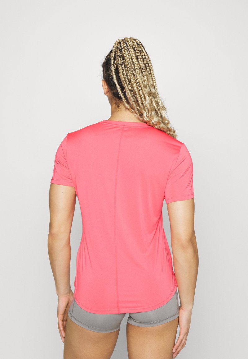 Camiseta deportiva de manga corta en rosa brillante, hecha de un tejido sintético ligero, diseño ajustado, con una textura suave y costuras mínimas.