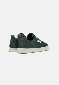 Sneaker in pelle verde con lacci bianchi, design a profilo basso, punta rotonda e suola in gomma bianca a contrasto. Accentuato da un dettaglio del logo.