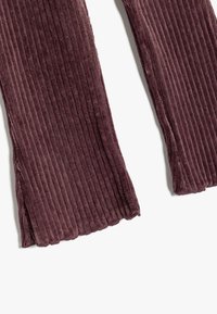 Paarse corduroybroek met verticale ribbelstructuur, met een onafgewerkte zoom en een losse pasvorm. Zacht materiaal voor comfort.
