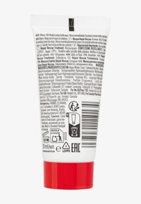 Tubetto bianco schiacciabile con tappo rosso, 30 ml. Presenta testo multilingue, istruzioni e elenco degli ingredienti stampati in nero sul retro.