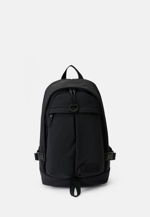 Black Hugo backpack with top handle, front zip pocket, side buckles, and branded logo on front bottom panel.