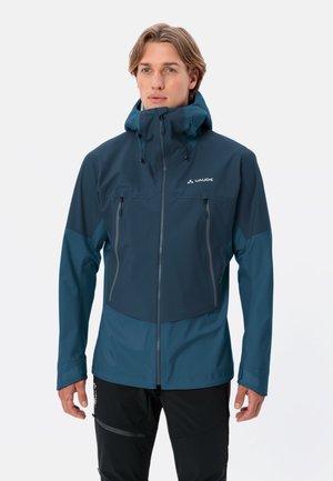 Veste imperméable pour homme en teal foncé, dotée d'une fermeture à glissière, d'une capuche et de deux poches sur la poitrine avec des zips gris. Texture douce, design fonctionnel.