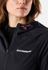 Zwarte hoodie met een rits, voorzien van een capuchon, roze trekkoord en een wit logo op de borst. Gladde textuur met een aansluitende pasvorm.