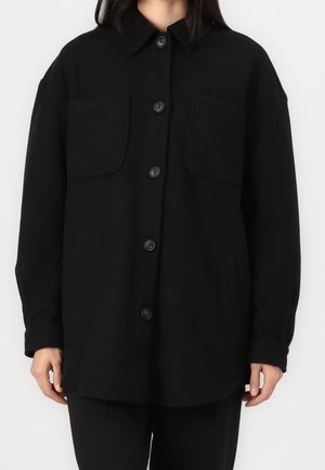Sort skjortejakke lavet af tykt stof, med krave, to frontlommer og en afslappet pasform. Glat tekstur med en subtil glans.