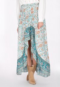 Luftig, teal og hvid blomster nederdel med h�øj-lav kant, med en smocket talje og indviklede paisley detaljer. Sammen med brune ankelstøvler.