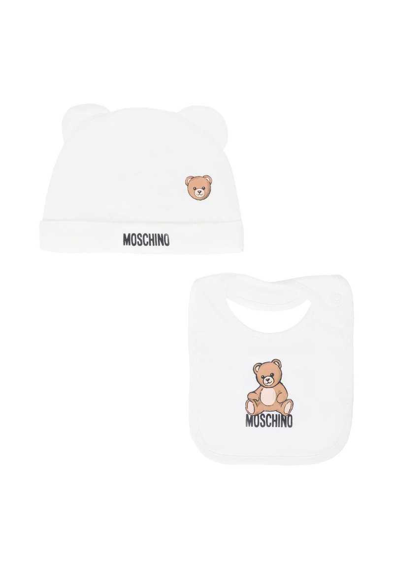 Cappellino bianco di cotone per neonati con orecchie da orso, con grafica di un orso e il logo "MOSCHINO". Accompagnato da un bavaglino abbinato con design di un orso.