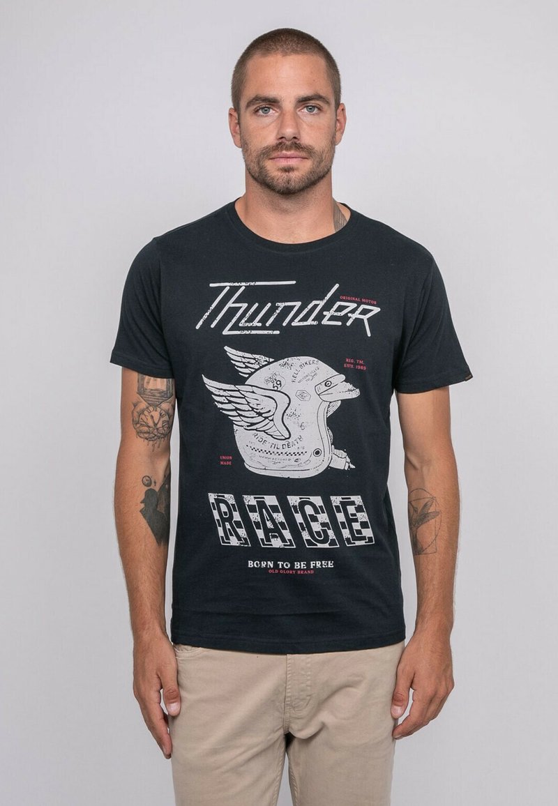 T-shirt en coton noir avec un imprimé graphique d'un casque avec des ailes et "Thunder RACE" en lettres épaisses. Manches courtes et style col rond.